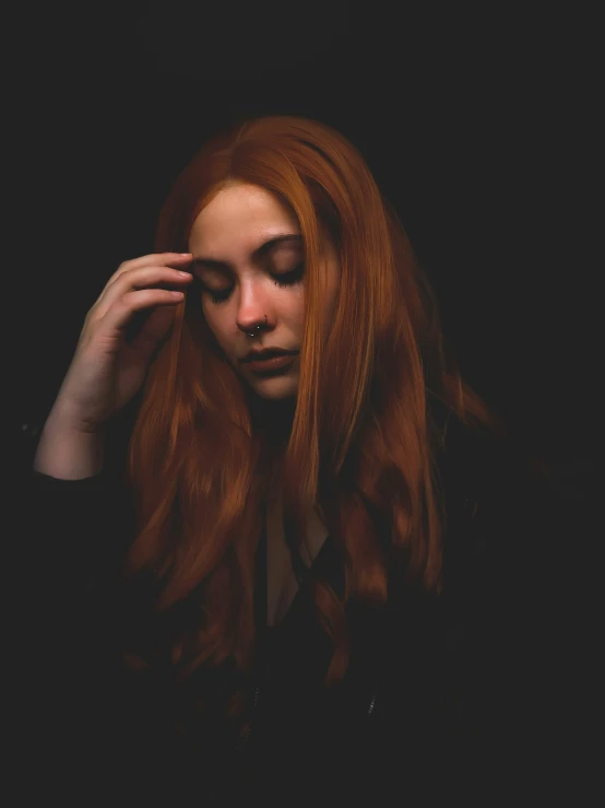 a woman with red hair in the darkness