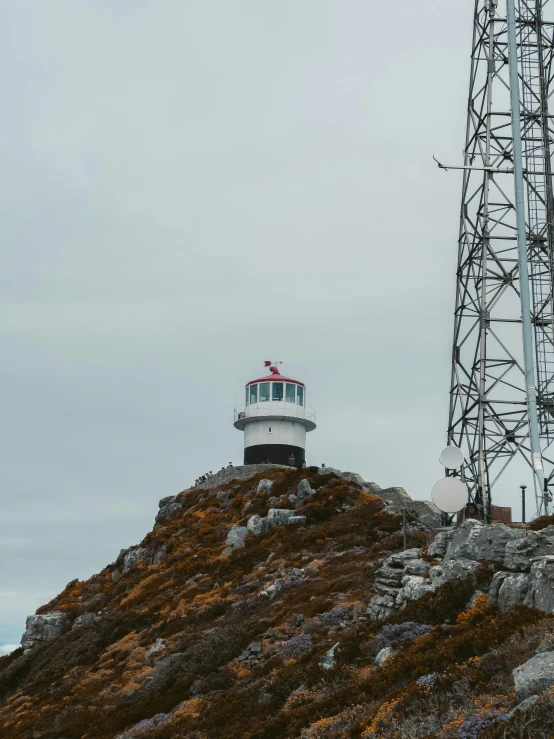 a cell tower stands atop the top of a rocky hill