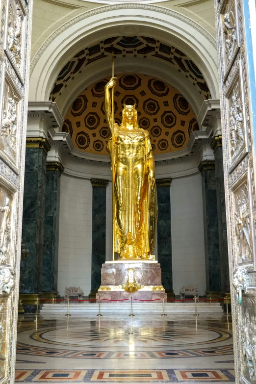 a gold statue sitting inside a stone building