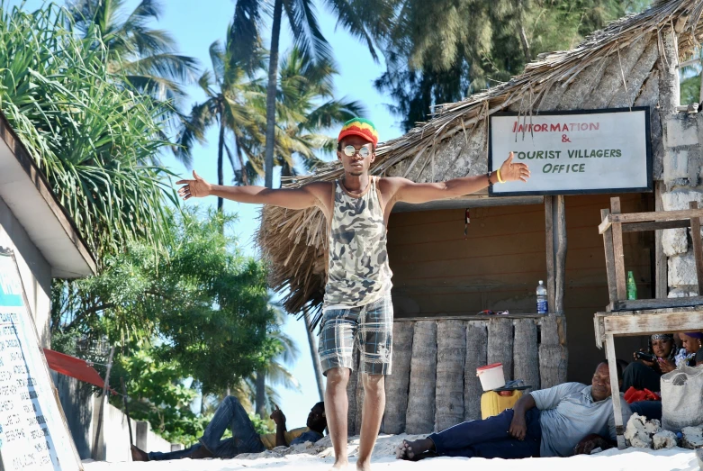 a man walking on the beach with his arms outstretched