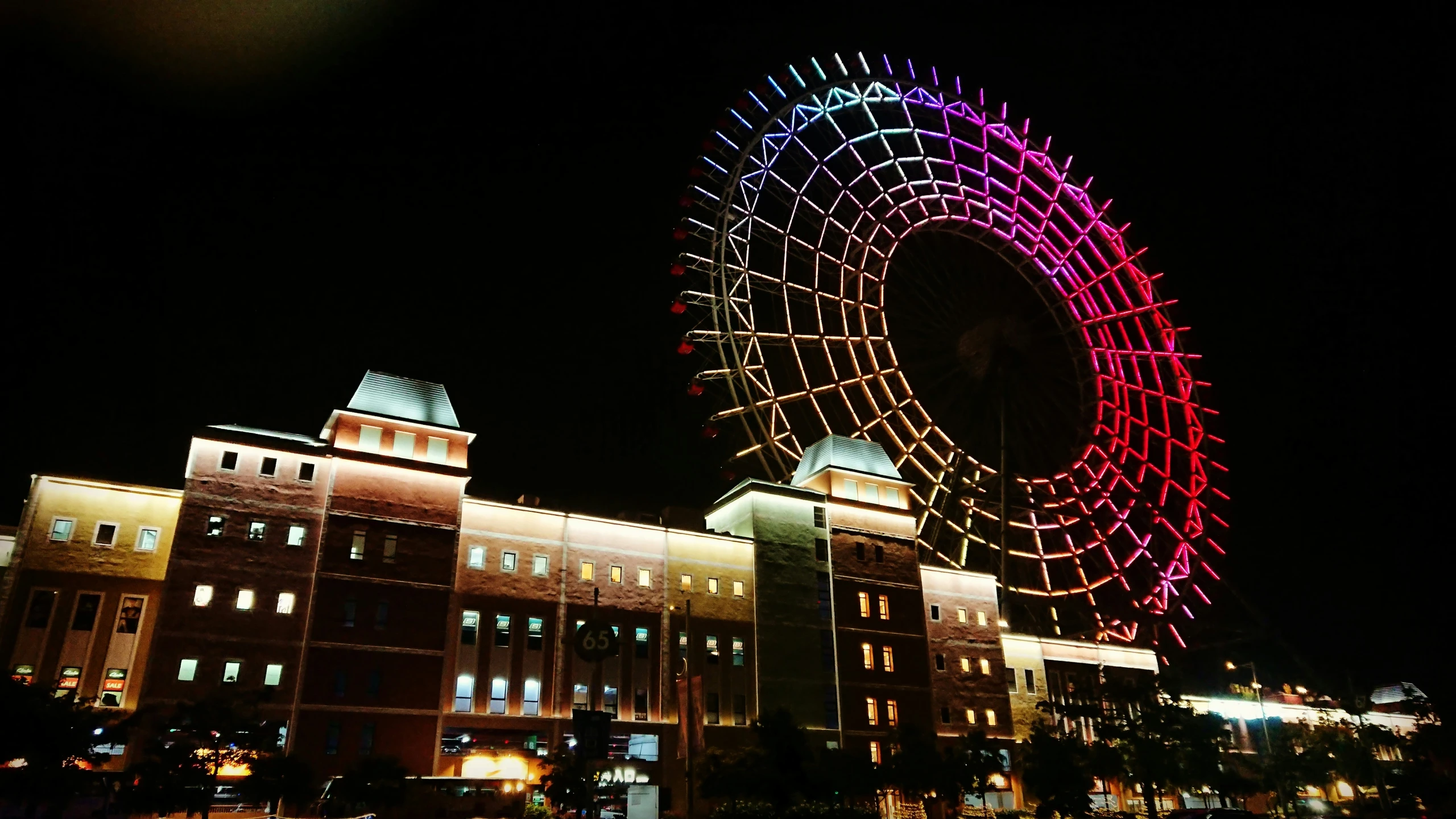 the building with the lighted ferris wheel in it