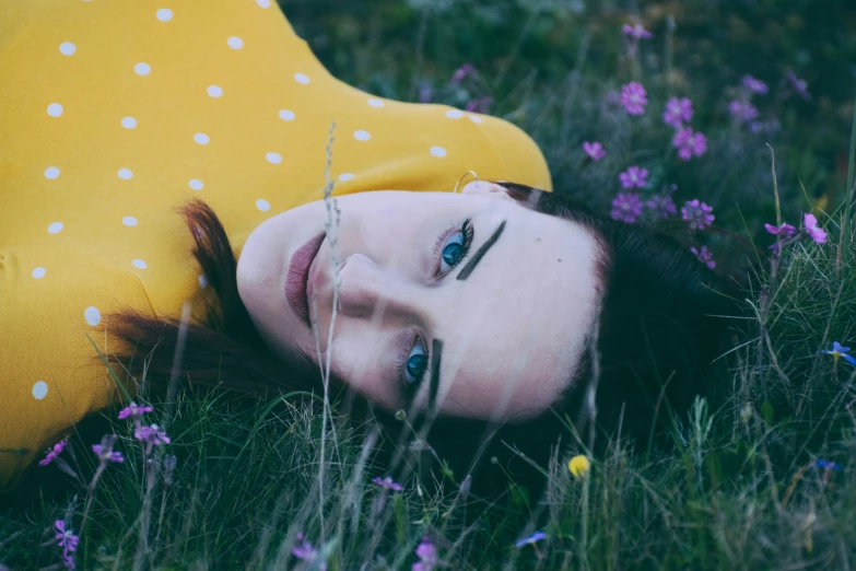 the woman is laying on the ground outside in the grass