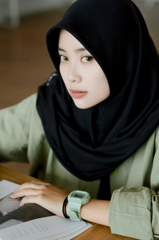 a woman in a hijab working at a table