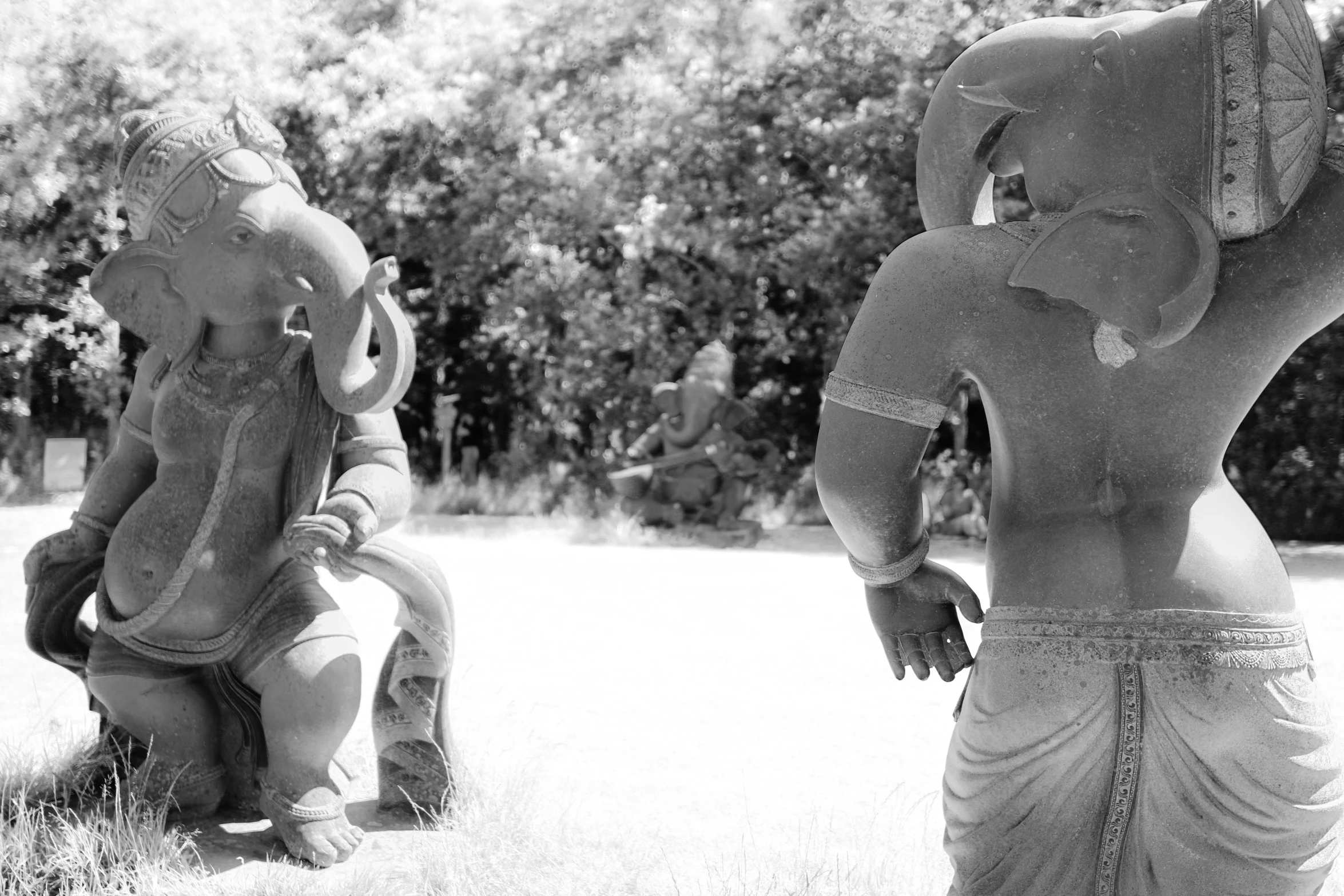 some sculptures in the grass near trees