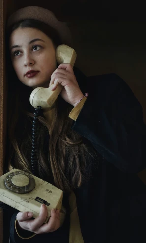 a  holding up an old fashioned telephone