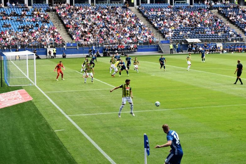 a group of people standing around a soccer field