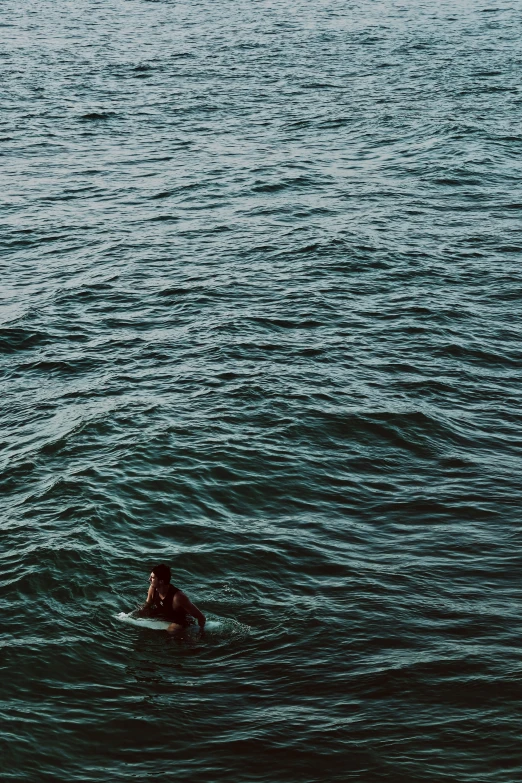 a surfer rides in to the shore of a large body of water