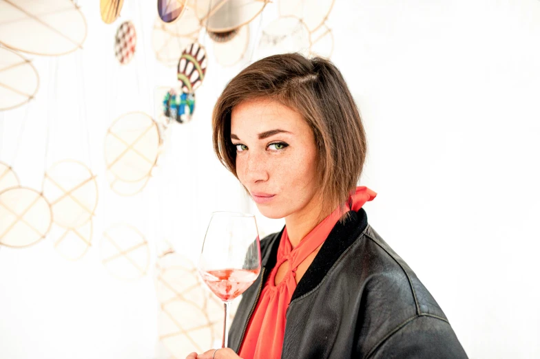 a young woman holding a wine glass with her hand