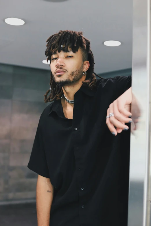 a young man with dreadlocks is standing in an elevator