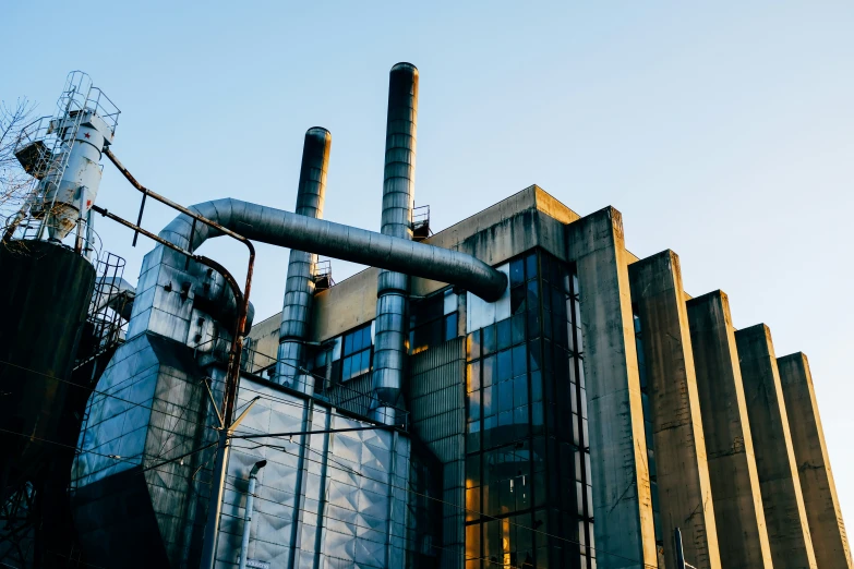 a very large industrial building with many pipes and windows