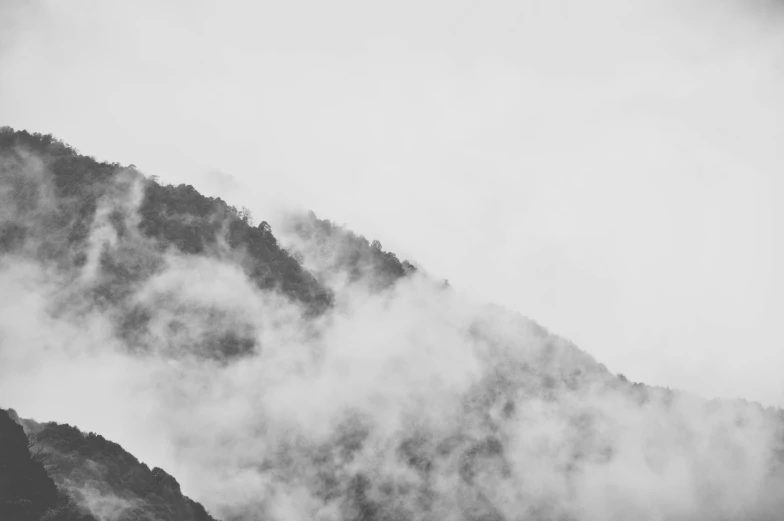 a small bird flying in a cloudy sky