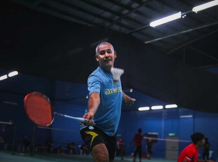 a man playing tennis on an indoor court