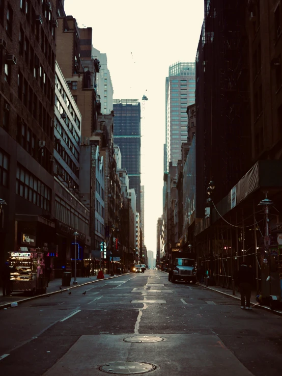 a empty city street with tall buildings at the end