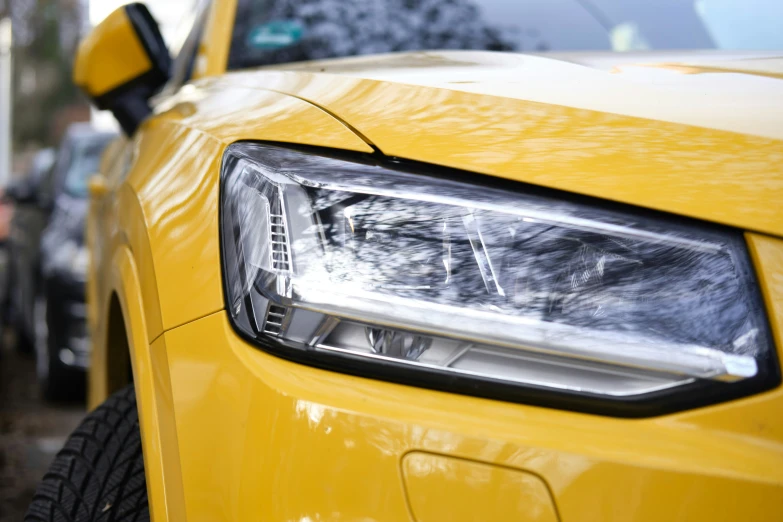 a close up po of the headlights of a yellow car