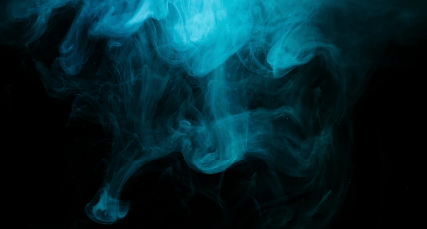 a blue smoke swirl is pographed on black background