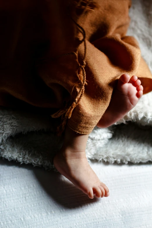 there is a baby feet tucked up on someone's back