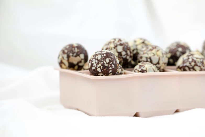 a pink container filled with chocolate covered truffles