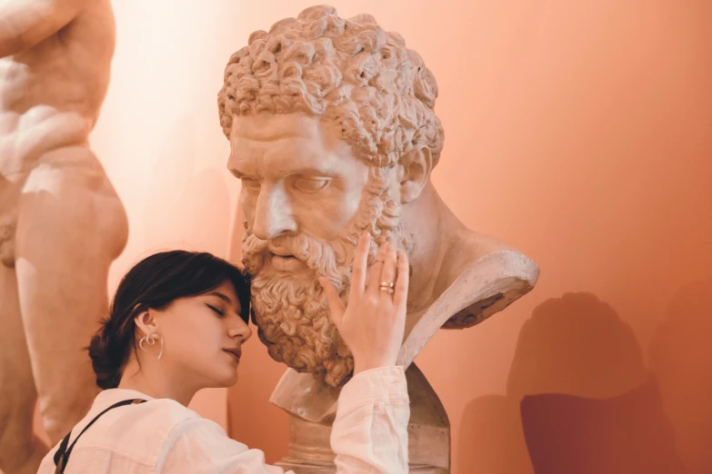 a woman touching her hand on a sculpture