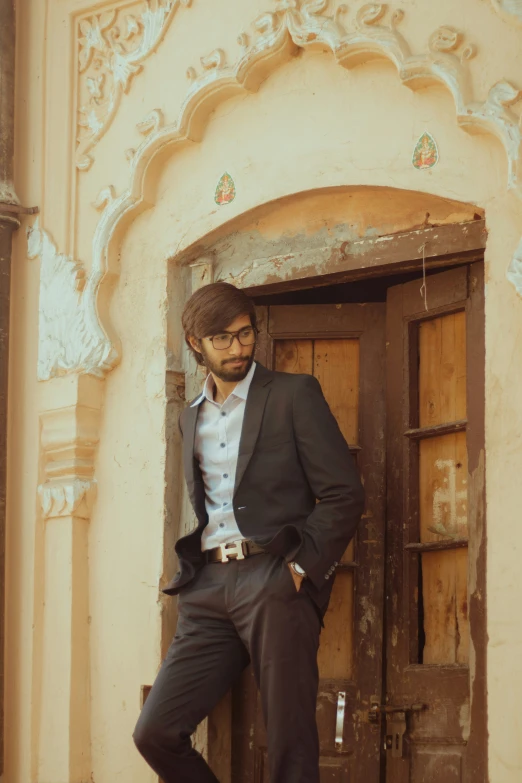 a man leans on an old door in front of a building