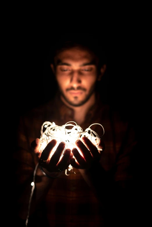 a man holds up some type of light inside his hands