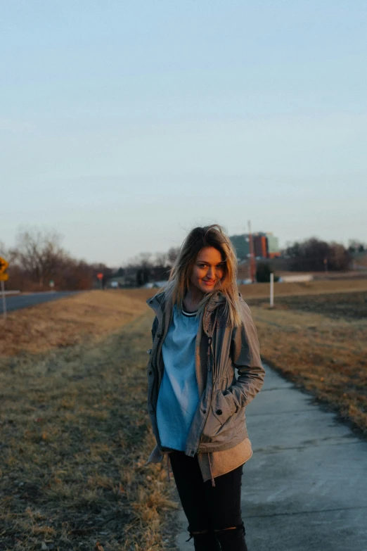 a woman standing on a sidewalk in the sun