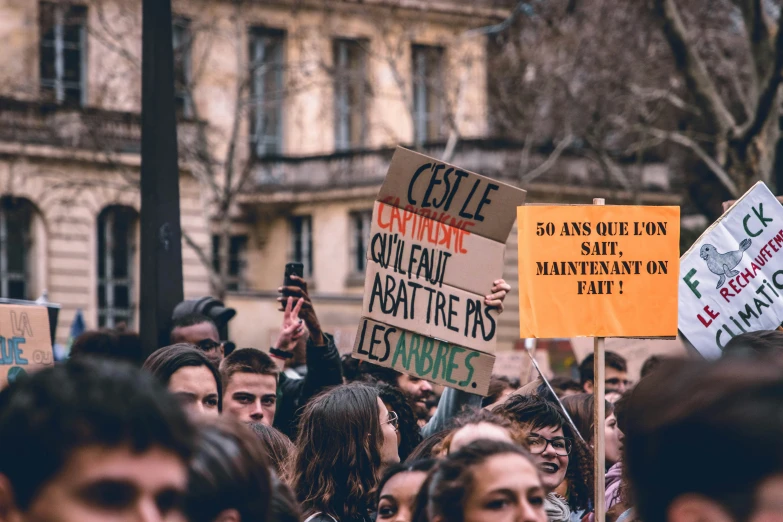 a large group of people on the street holding signs