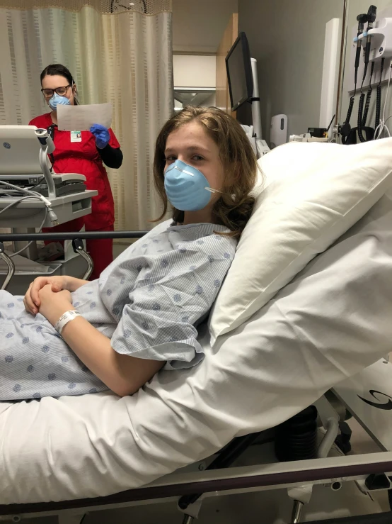 woman in hospital gowns with mask covering her face