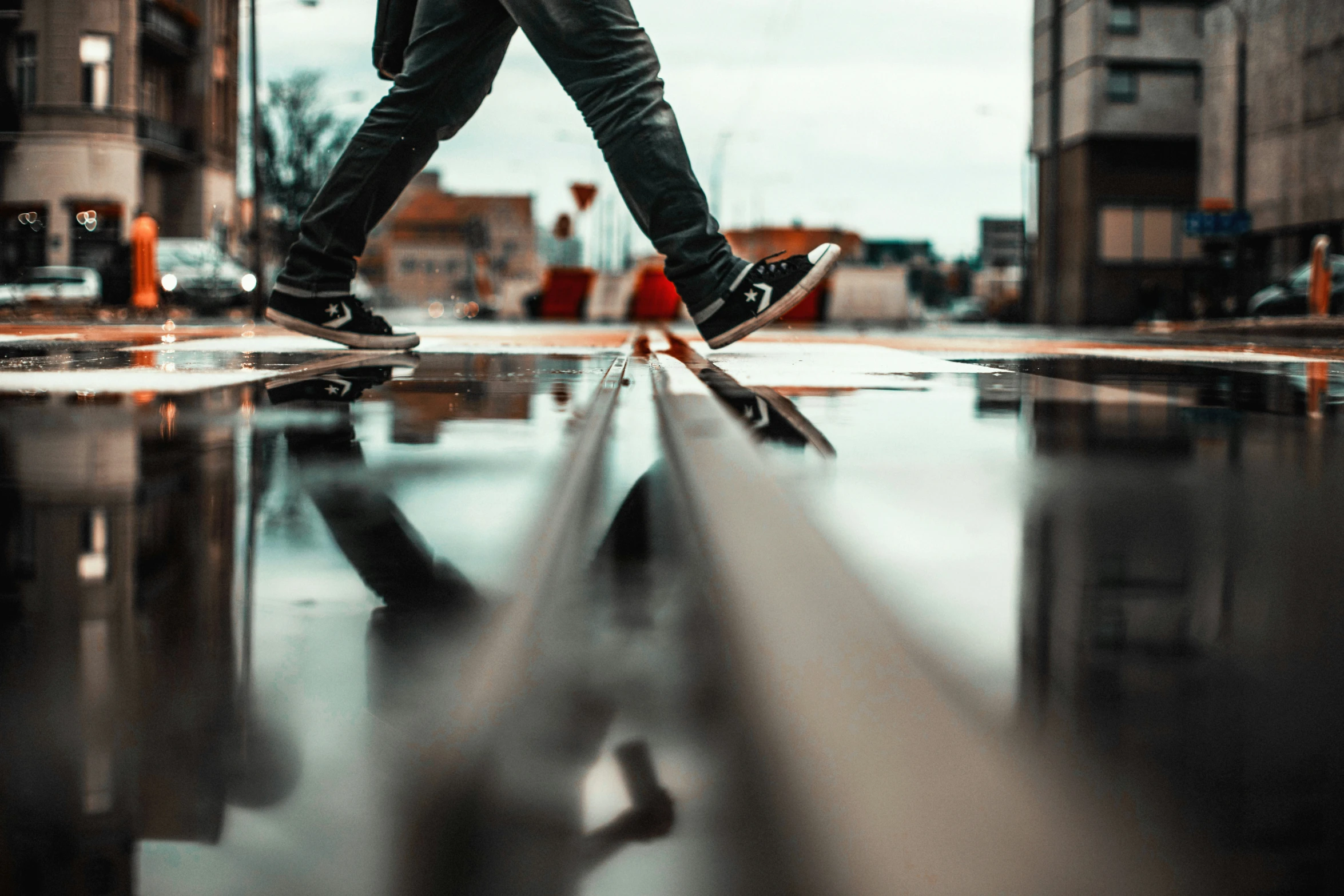 a person walks over a wet, surface - covered sidewalk