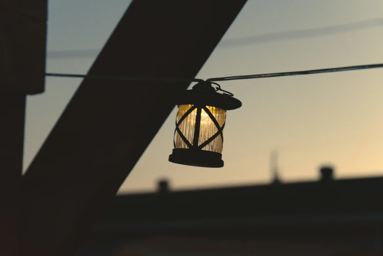 a street light suspended over some wires in front of a sky