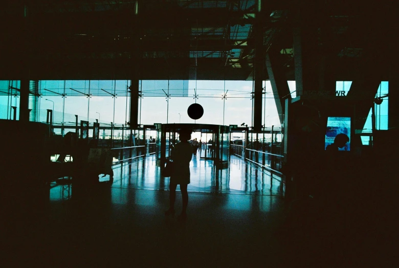 silhouettes of people walking along the airport corridor