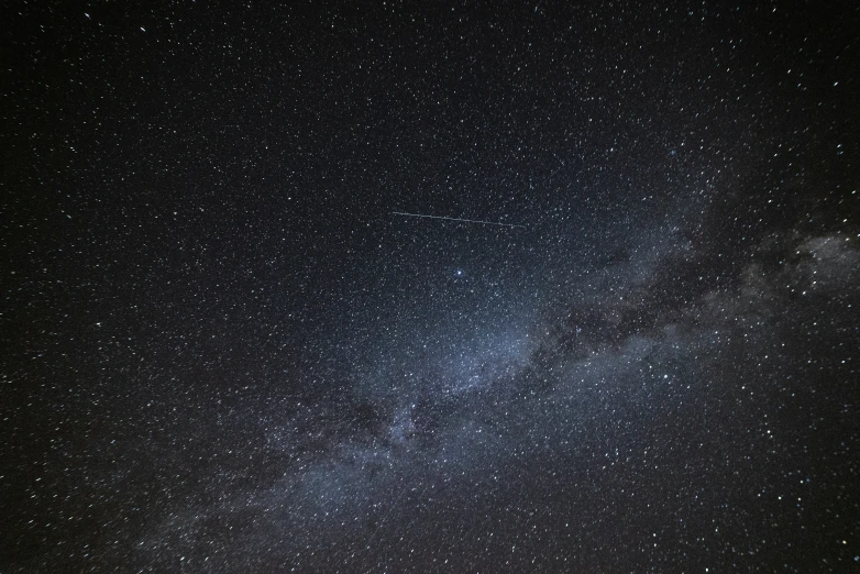 a lone person standing on a hill under stars