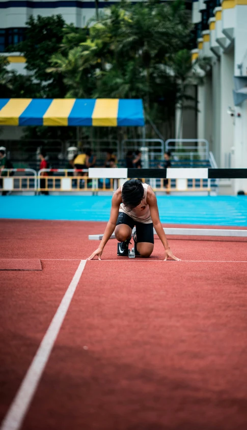 a person laying on a red court while kneeling down