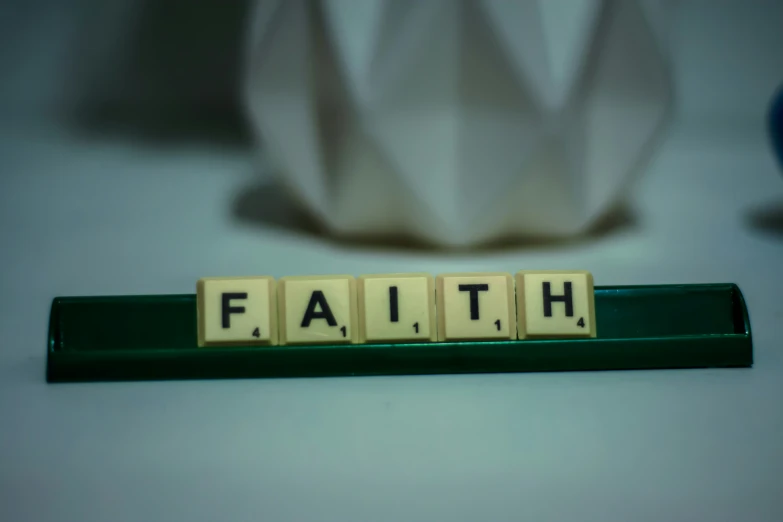 scrabble block letters are arranged across the word faith