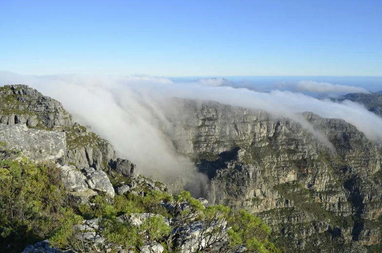 clouds hanging over a mountain in a valley