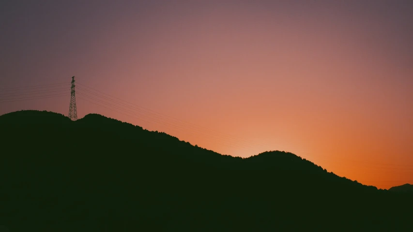 a couple of hills on the edge of a sunset