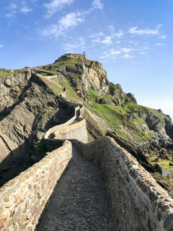 this is an old stone wall that's next to a steep hill