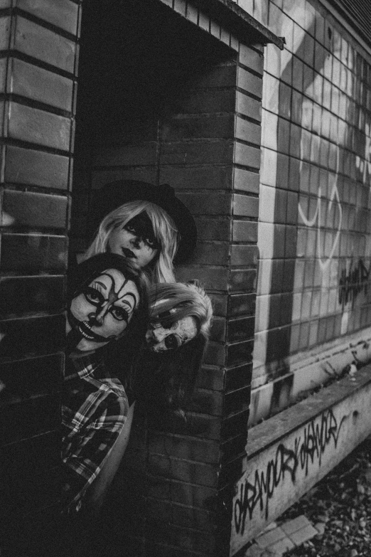 a girl in a jacket leaning against a brick wall