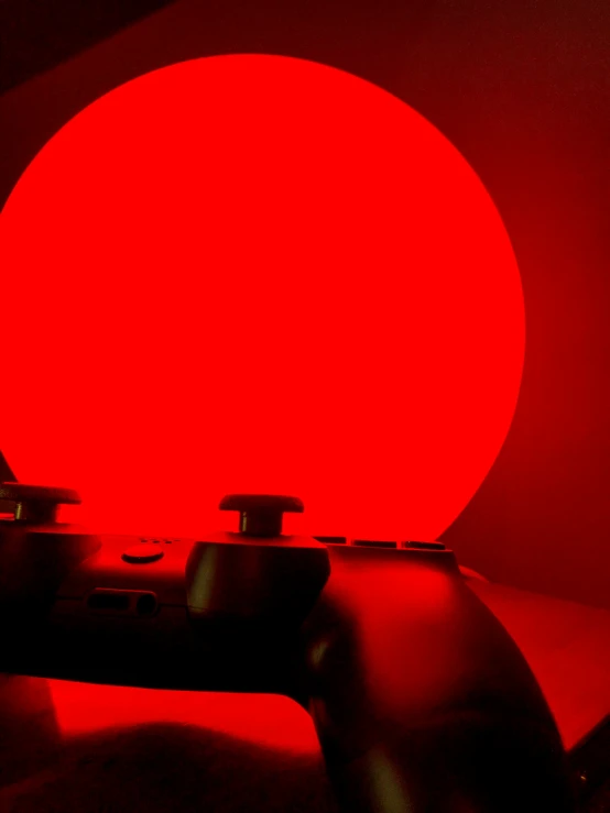 a video game controller is lit up in the dark