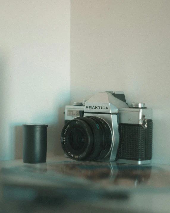 a camera and cup sitting on a table