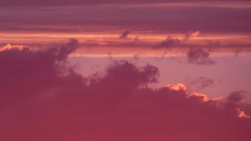 a sunset that is pink with yellow and purple clouds