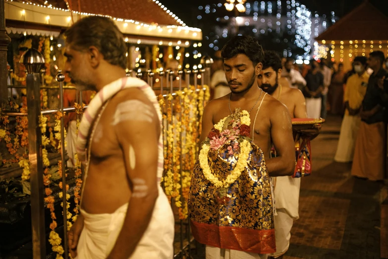 several men are dressed up and standing in front of many beads