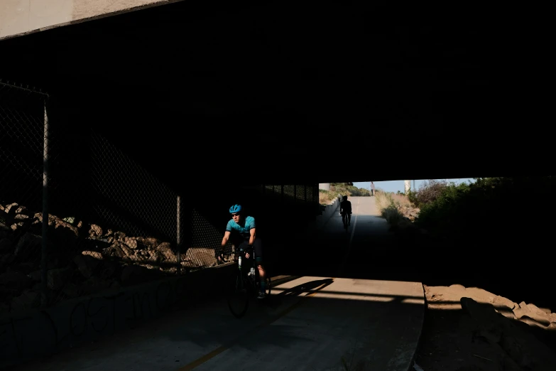 person in helmet on bike riding through a tunnel