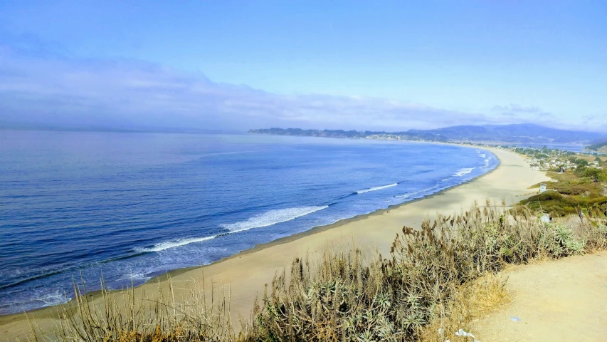 the ocean is pictured from a height high above the beach