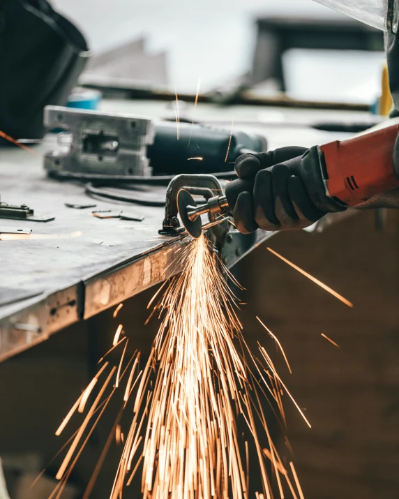 welder with protective work gloves  metal and lighting a piece