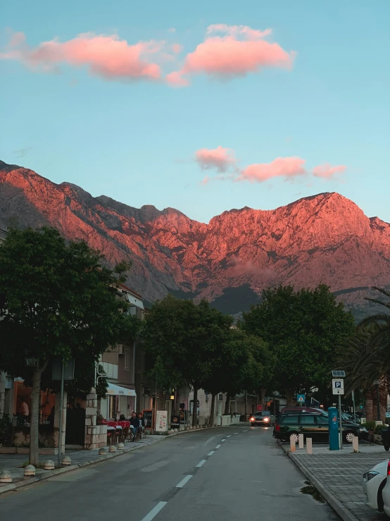 a street with cars on it and the mountains in the background