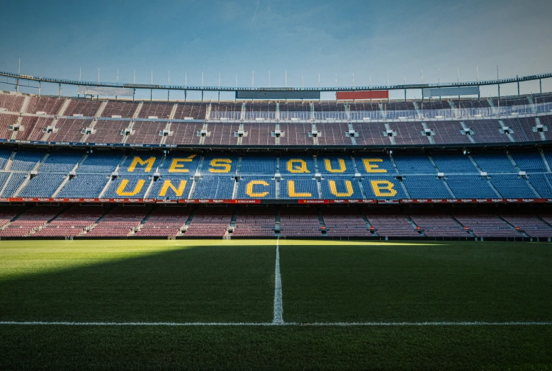 an empty soccer stadium that has a banner in the middle