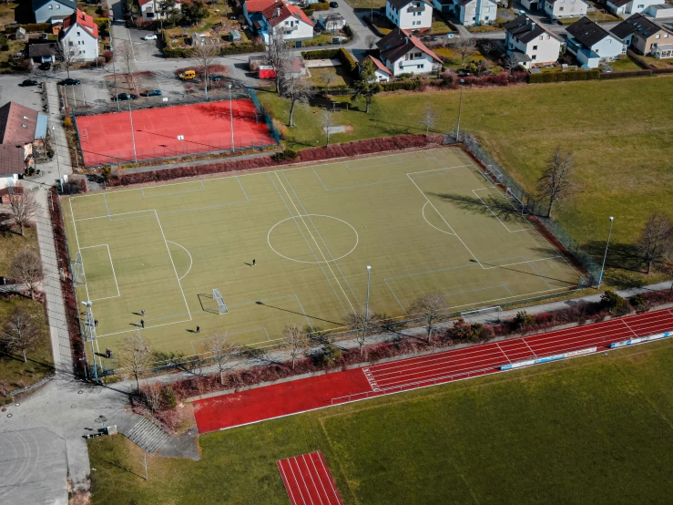 an aerial view of a soccer field and many houses