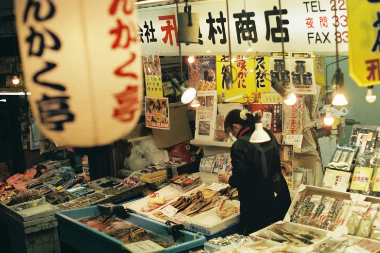 a woman in ear phones standing in front of an open market