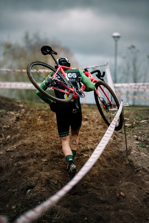 a man carrying his bike up the hill