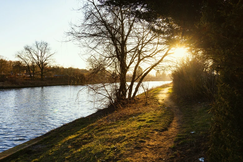 a man is walking along a path next to the water